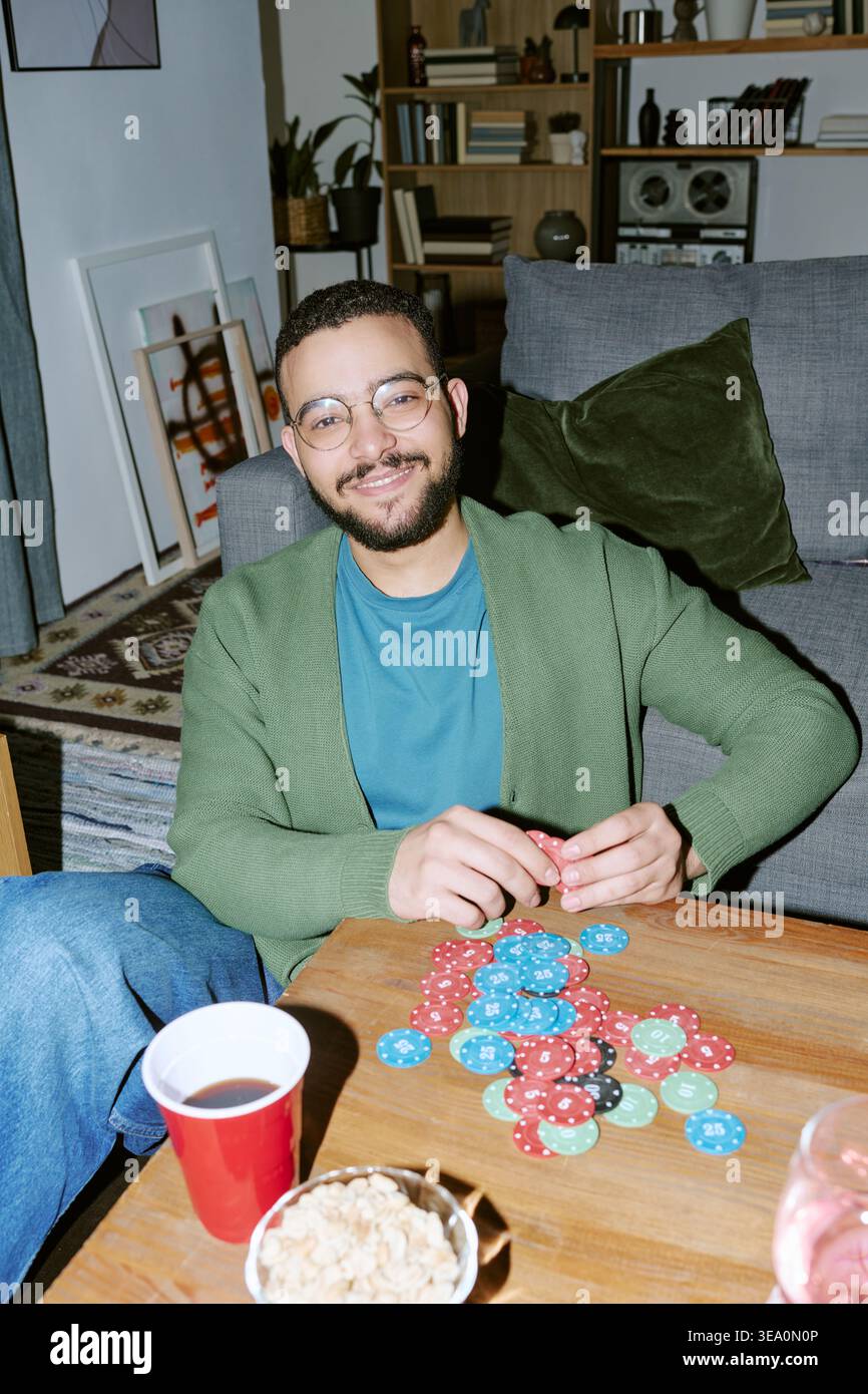 Ritratto dell'uomo che gioca a poker durante la serata della partita in casa Foto Stock