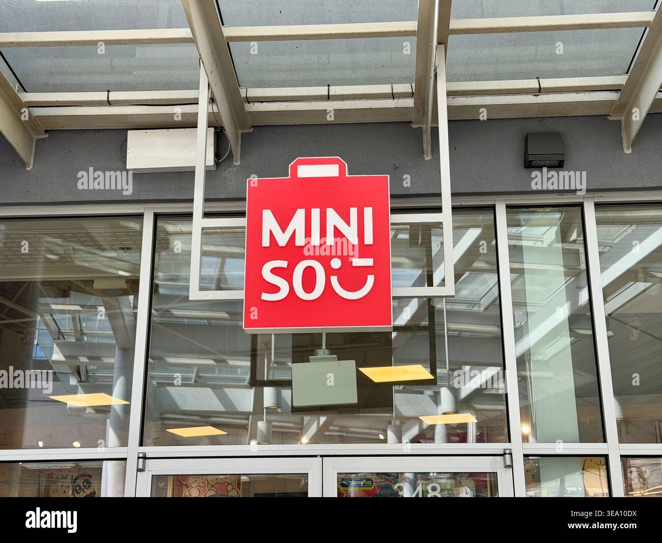 Logo del negozio MINISO presso New West (New Westminster Station) a New Westminster, BC, Canada. Facciata moderna con marchio rosso. Foto Stock