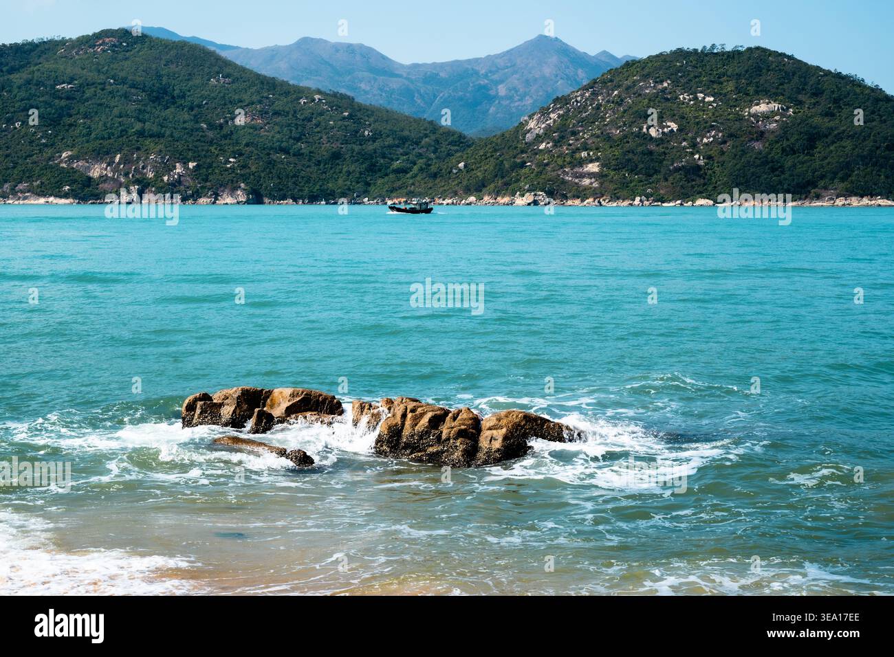 Onde che si infrangono dolcemente sulle rocce al largo della costa di Cheung Chau, Hong Kong Foto Stock