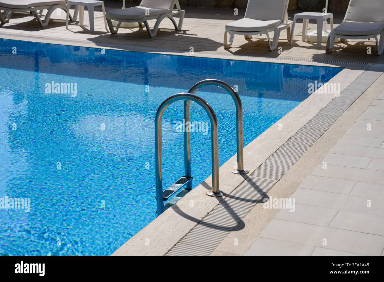 Manutenzione professionale della piscina, servizio di disinfezione. Acqua azzurra cristallina con scala, igiene, trattamento dell'acqua, filtrazione, bilanciamento chimico pubblico, piscine private, controllo del bilanciamento del pH Foto Stock