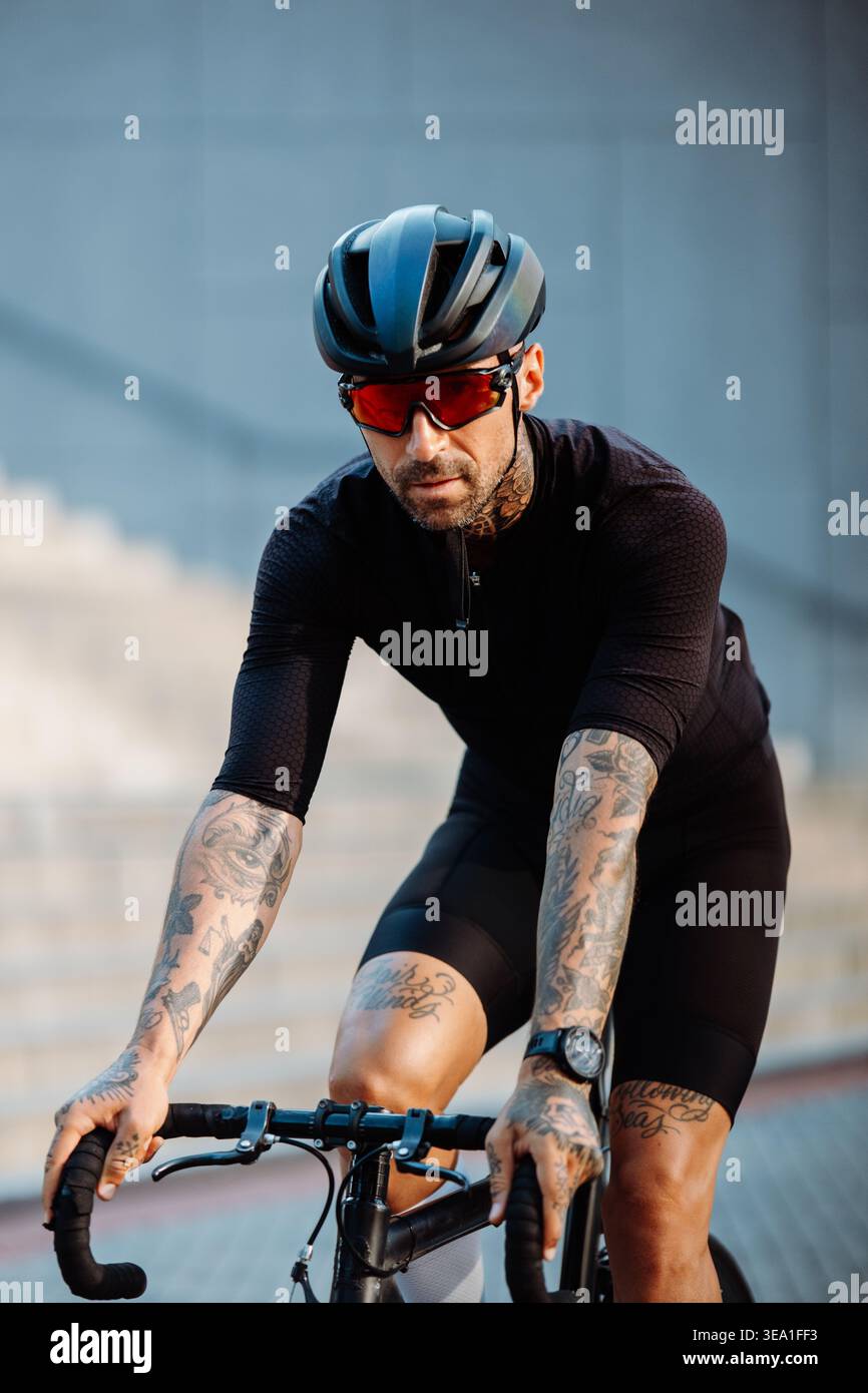 Outdoor male Rider in rapida accelerazione. Corsa dinamica per ciclisti maschili attraverso la città Foto Stock