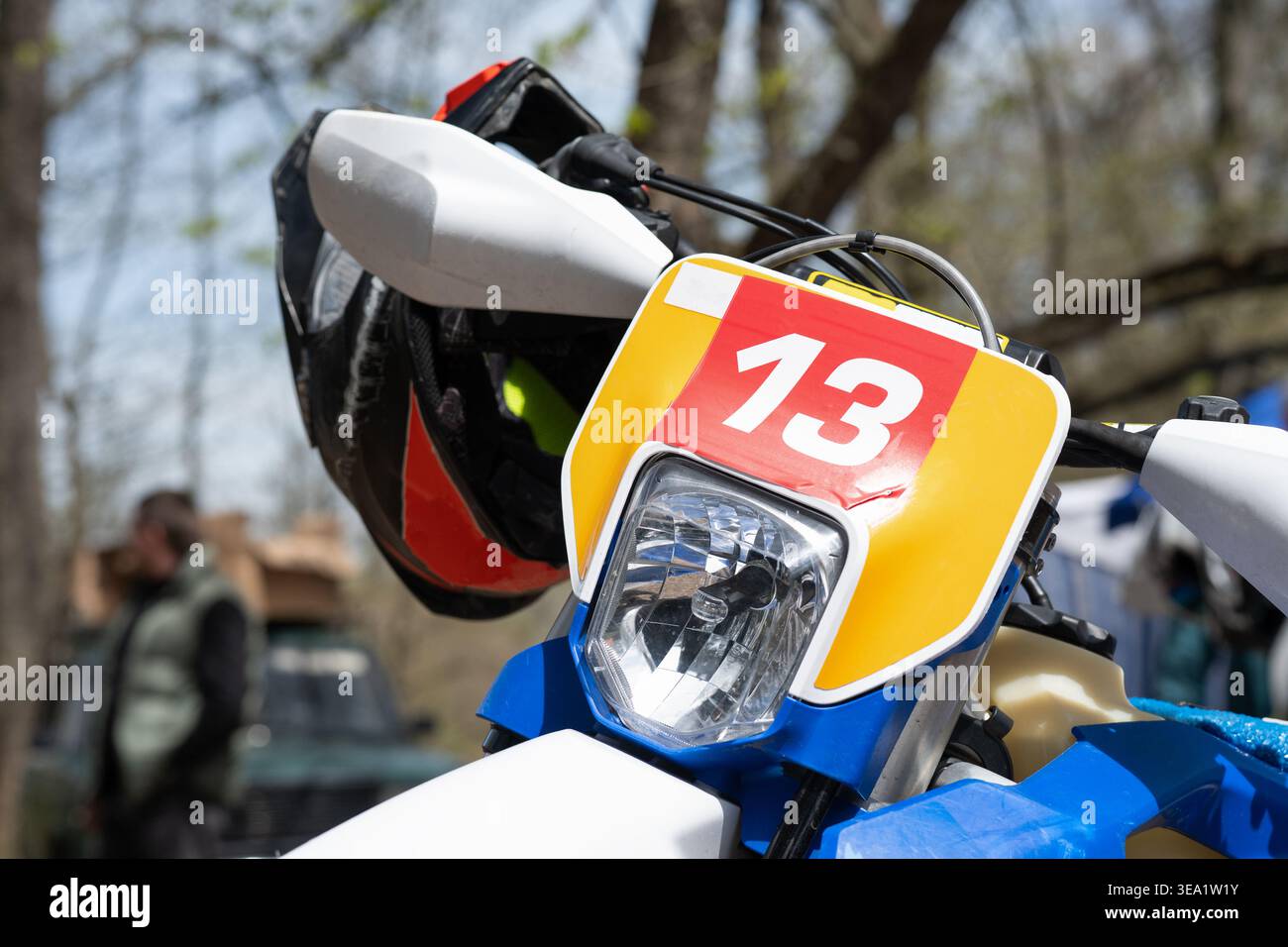 Primo piano di una motocicletta enduro con il numero di gara 13, simbolo spesso associato alla fortuna e alla superstizione negli sport estremi, parcheggiata in motocross Foto Stock