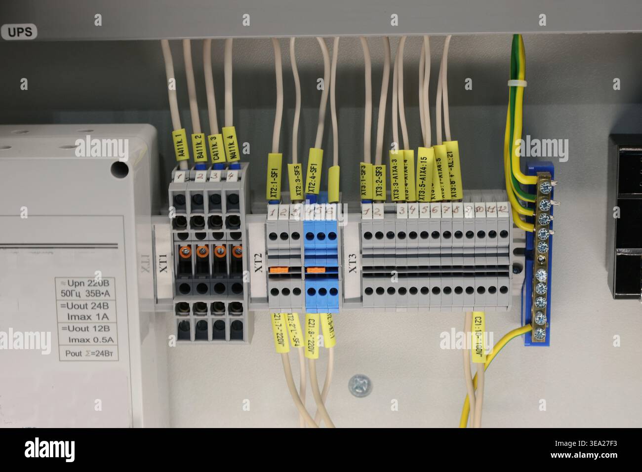 Un gruppo di fili è collegato a una scatola con etichette gialle. Quadro elettrico, contatti, interruttori, commutazione. Foto Stock