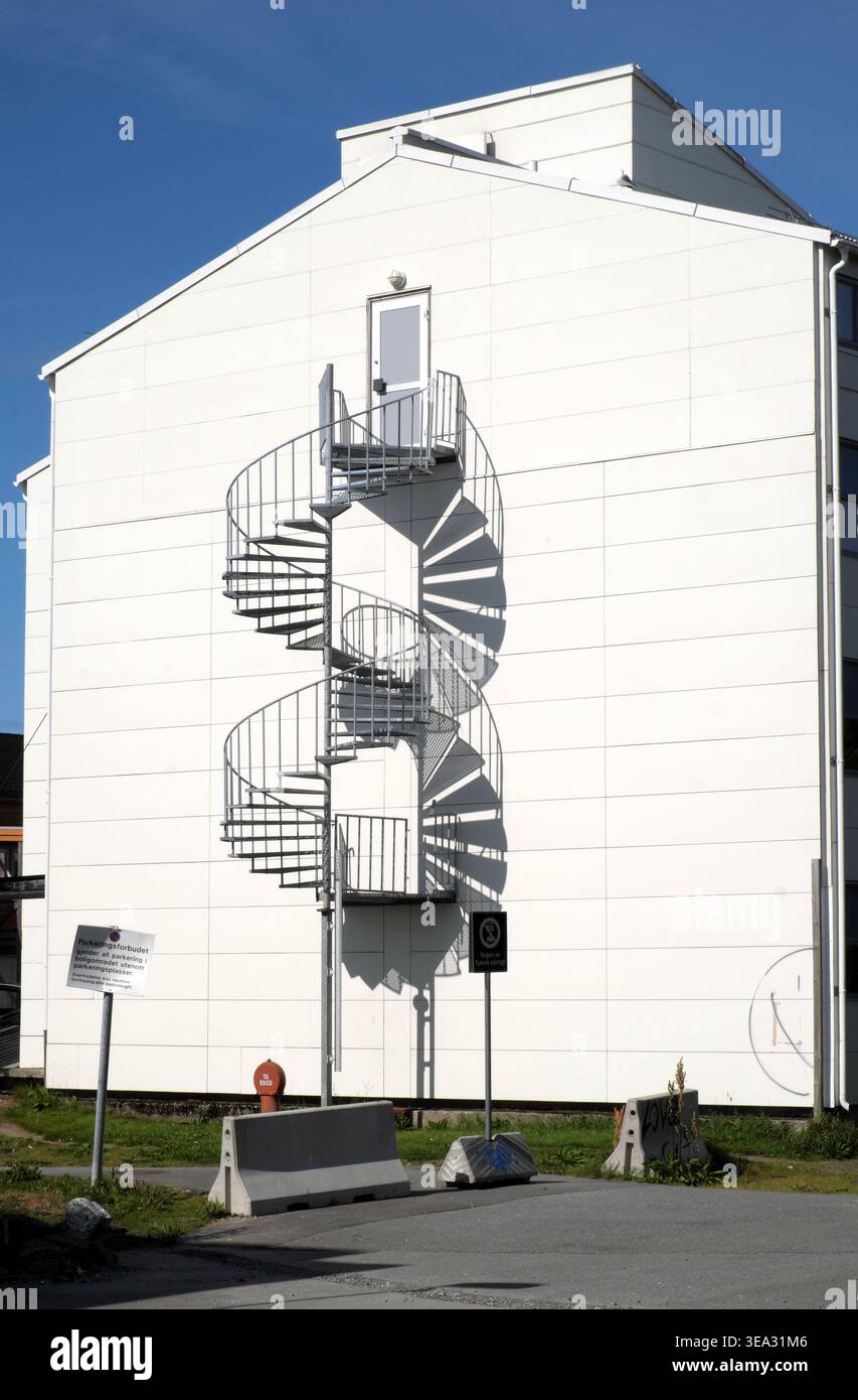 Scala a chiocciola, con la sua ombra, all'estremità di un edificio, Tromso, Troms, Norvegia. Foto Stock