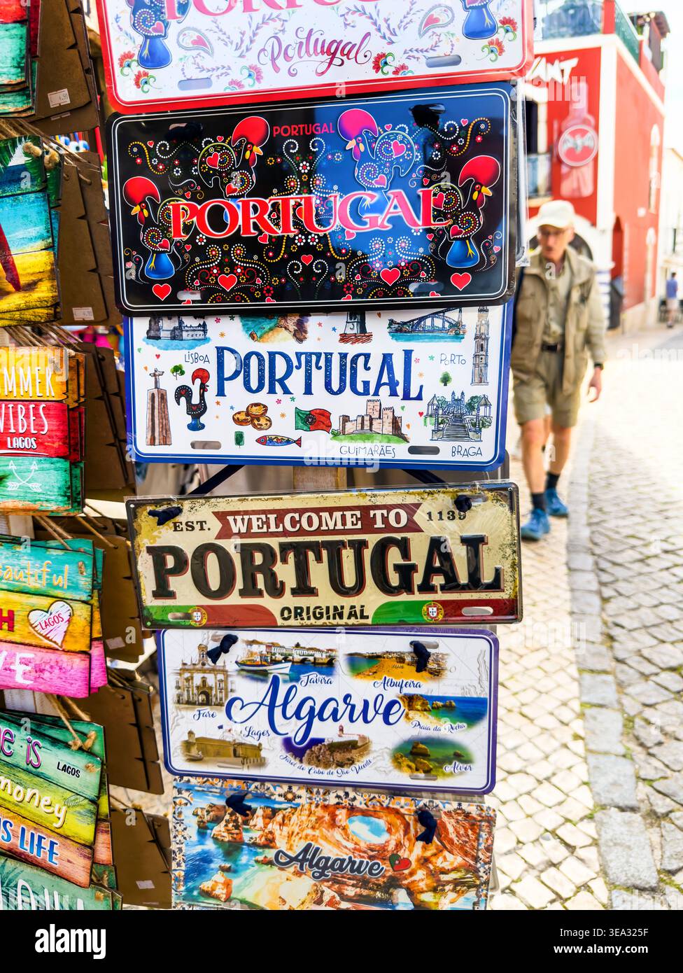 Selezione di piatti e cartelli con souvenir colorati e marchi Portogallo e Algarve esposti fuori da un negozio di articoli da regalo nella città storica di Lagos Foto Stock