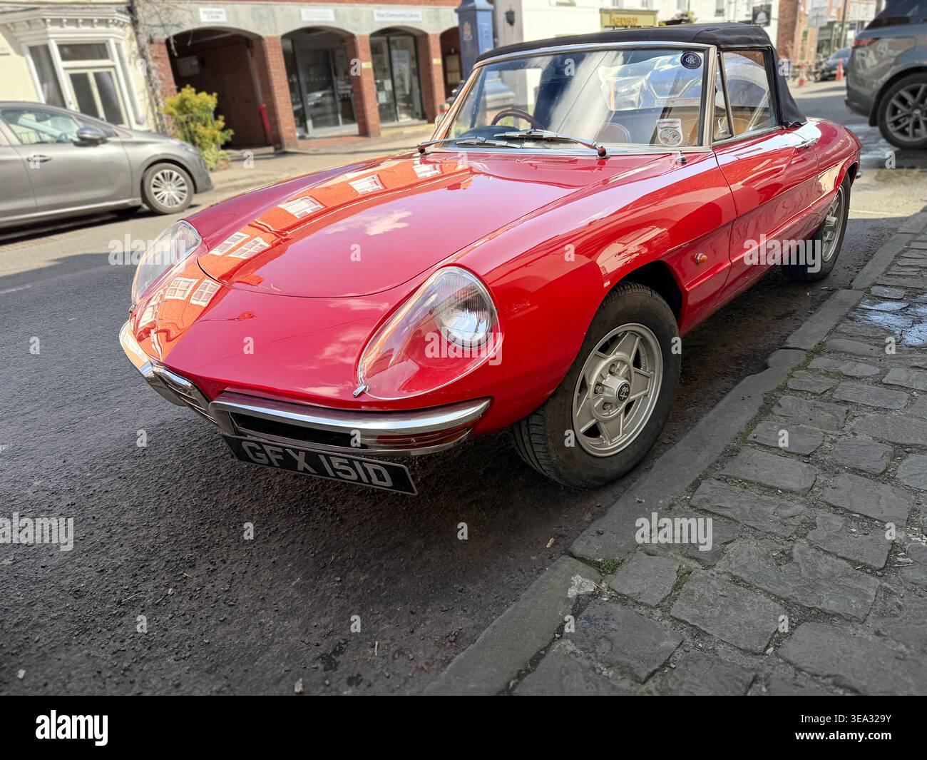 Alfa Romeo Spider Duetto rosso vintage anni '1960, auto decappottabile parcheggiata in una strada nel Regno Unito - Immagine stock catturata con smartphone