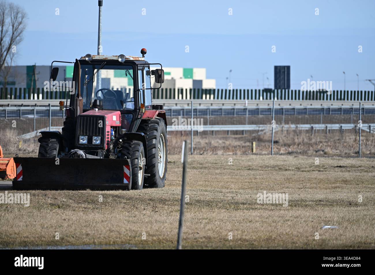 Piccolo trattore parcheggiato sul prato erboso in campagna Foto Stock