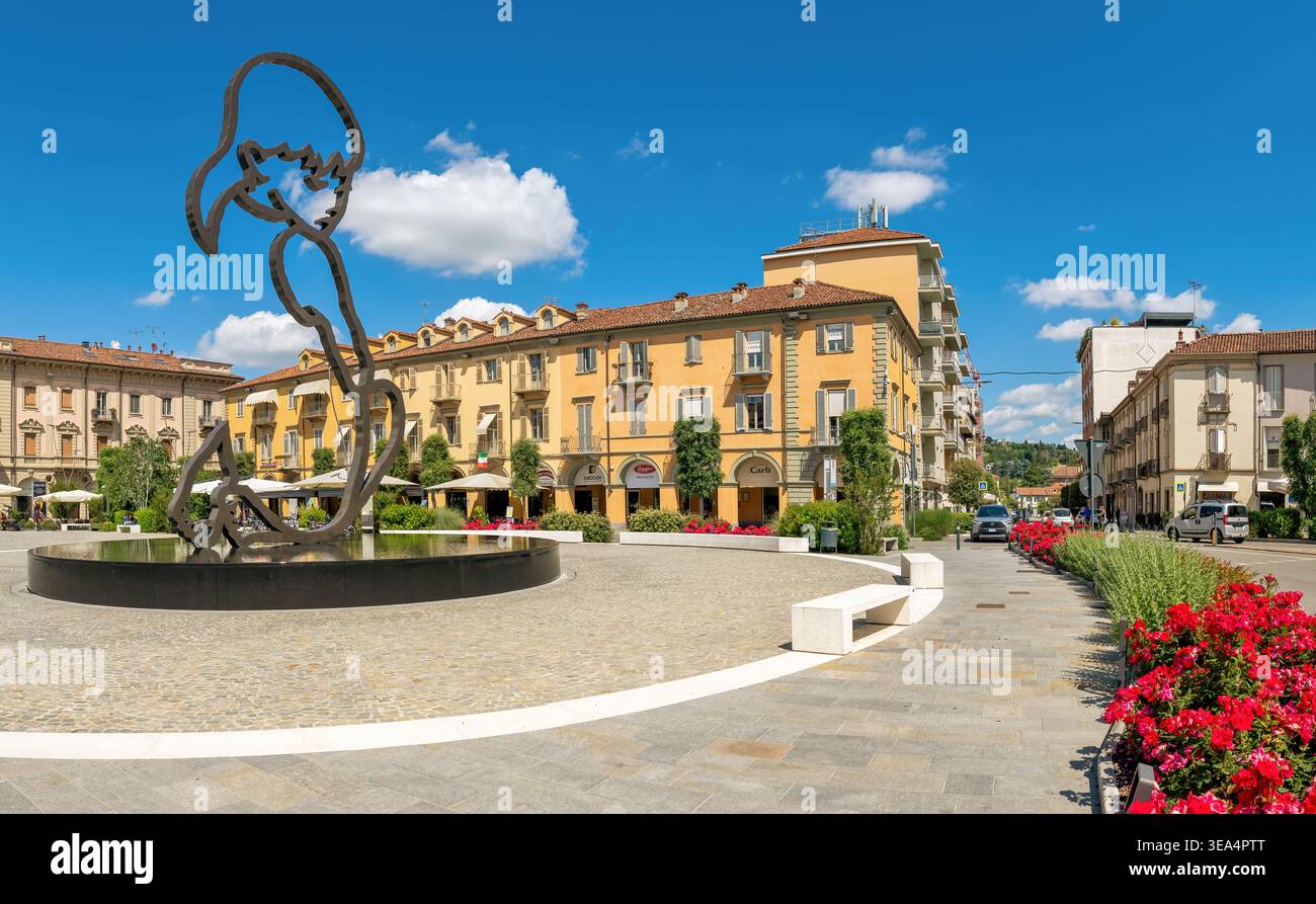 Piazza Michele Ferrero con una fontana, una scultura contemporanea ed edifici colorati ad Alba, Italia Foto Stock