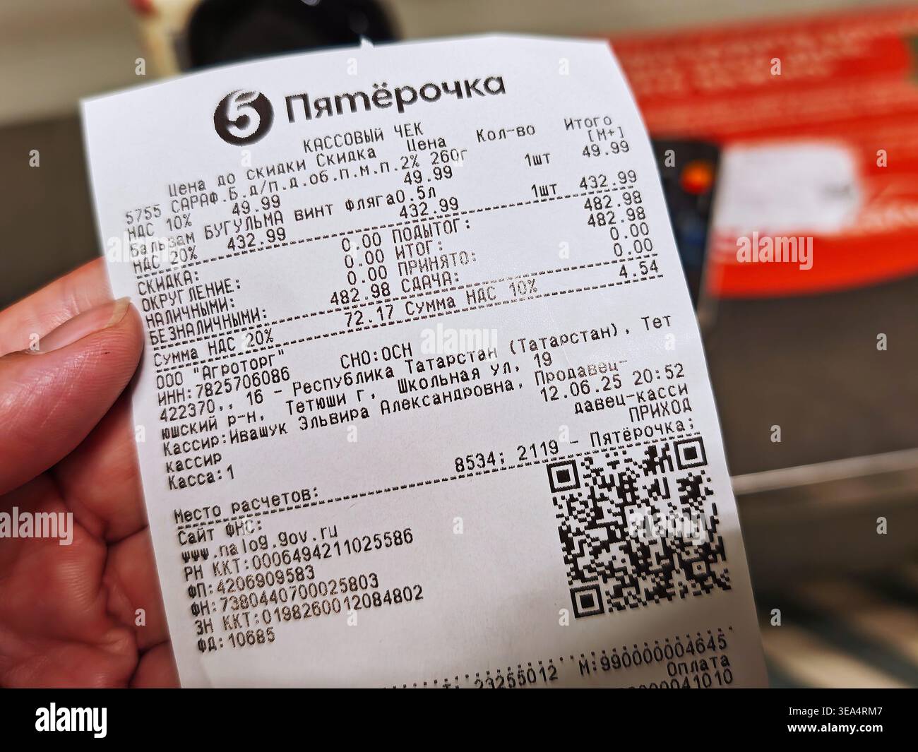 Tetyushi, Russia - 12 giugno 2026: Una persona detiene una ricevuta da un negozio di alimentari in Tatarstan, che mostra gli articoli acquistati, il costo totale e i dettagli di pagamento Foto Stock