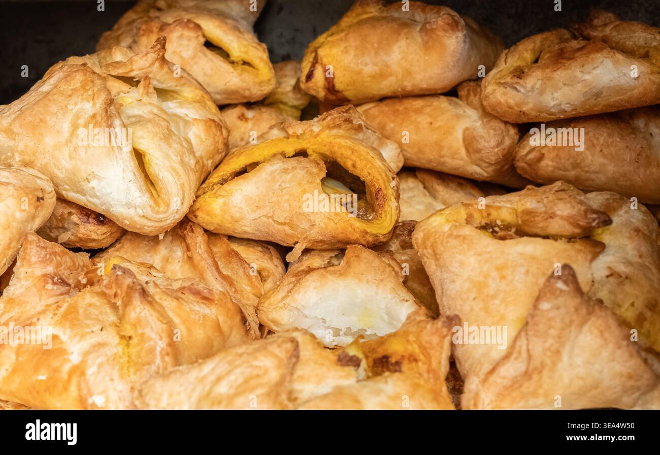 Strati di pasta sfoglia sfoglia. Primo piano: Bocconcini di formaggio ripieni di pollo o verdure in mostra al mercato del cibo di strada, attenzione selettiva, nessuno. Spuntino Foto Stock