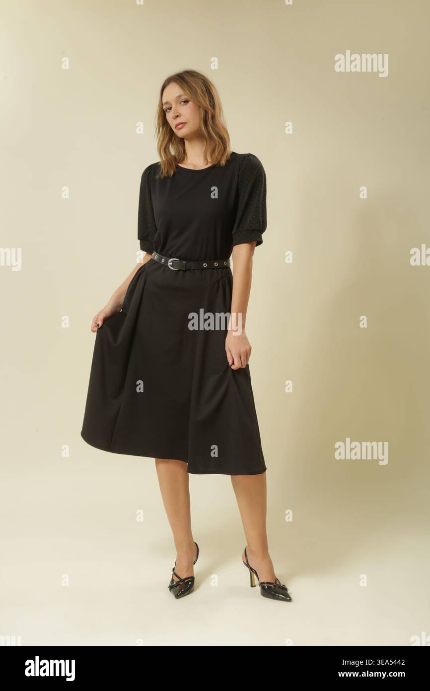 Ritratto di moda da studio di donna in abito A-line nero A manica corta con cintura - stile classico e senza tempo Foto Stock