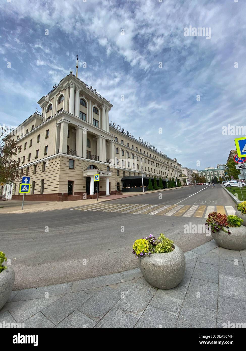 Belgorod, Russia - 8 agosto 2021: Strada cittadina con edificio di architettura classica a Belgorod, Russia, vista urbana ad ampio angolo con passerella e nuvoloso - Immagine stock catturata con smartphone