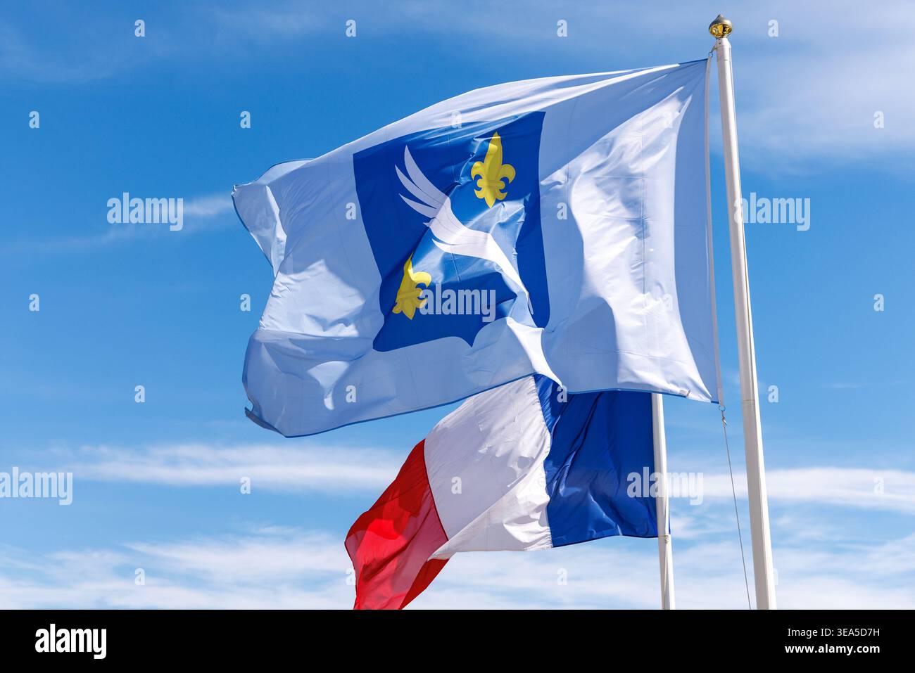 Cannes, Francia - 28.03.2026: La bandiera comunale di Cannes, con palme d'argento e gigli dorati su sfondo blu, ondeggia a fianco dei francesi Foto Stock