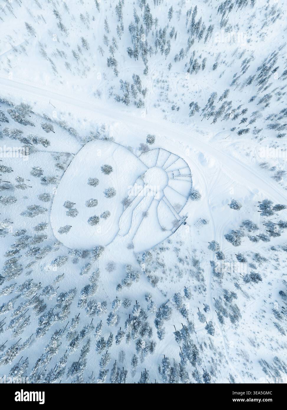 Vista aerea di un tradizionale corral di renne circondato da una fitta foresta di pini ricoperta di neve profonda in Lapponia, Finlandia. Foto Stock
