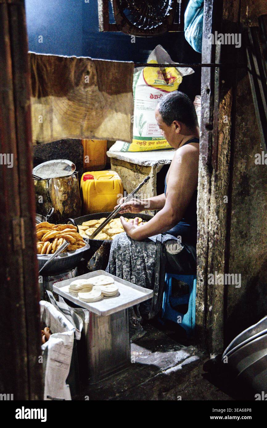 Uomo che frigge pane tibetano, Kathmandu, Nepal Foto Stock