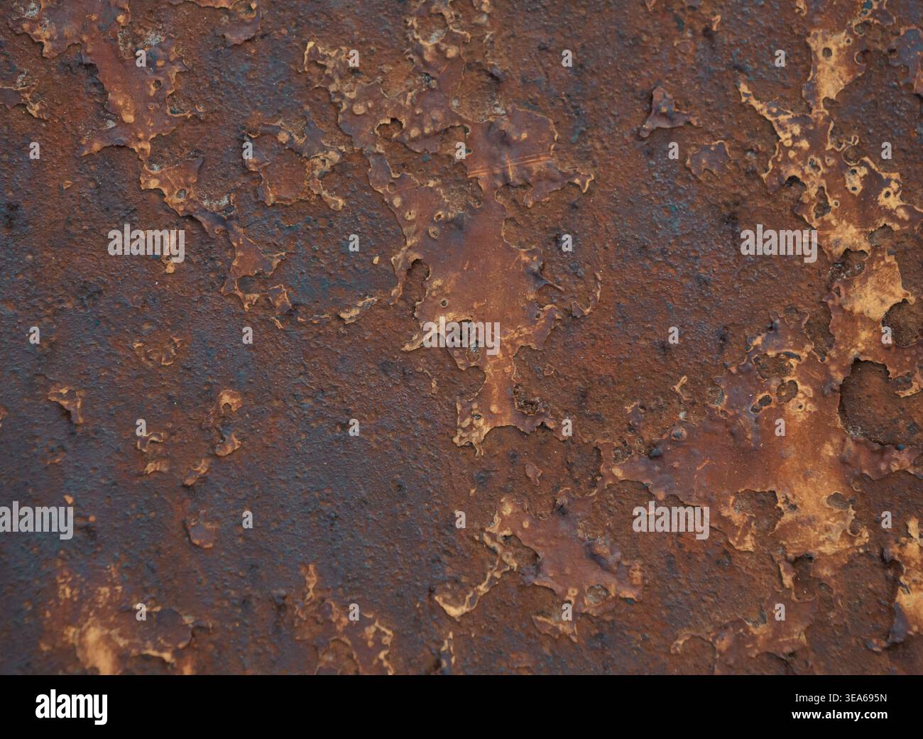 Vista dettagliata di una superficie metallica fortemente corrosa con strati di ruggine marrone e arancio scuro Foto Stock