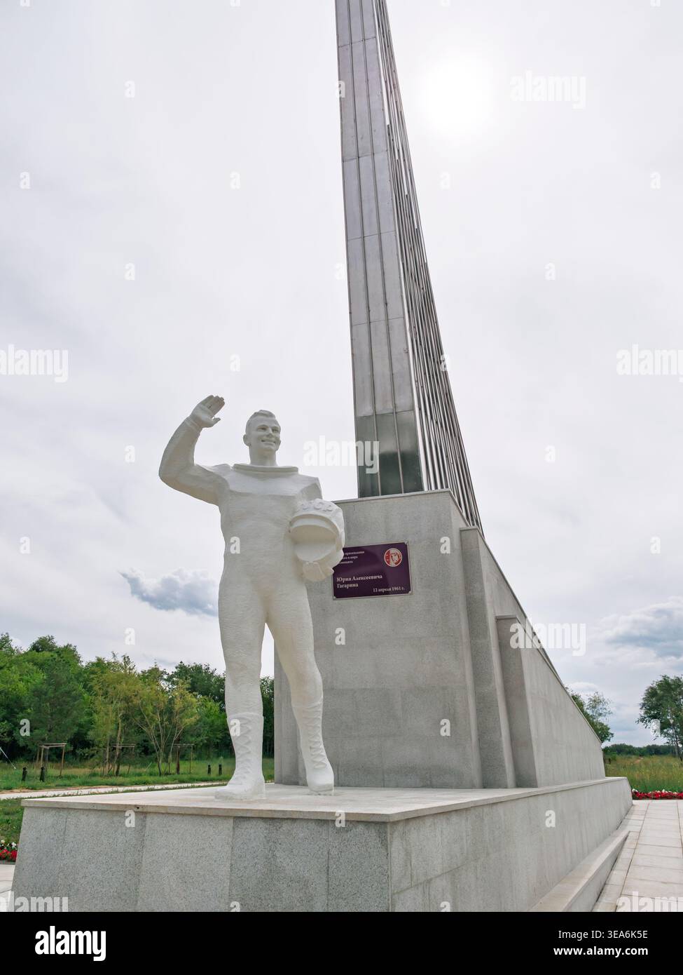 Statua del cosmonauta Yuri Gagarin in onore dell'esplorazione spaziale con un elegante monumento sotto un cielo nuvoloso Foto Stock