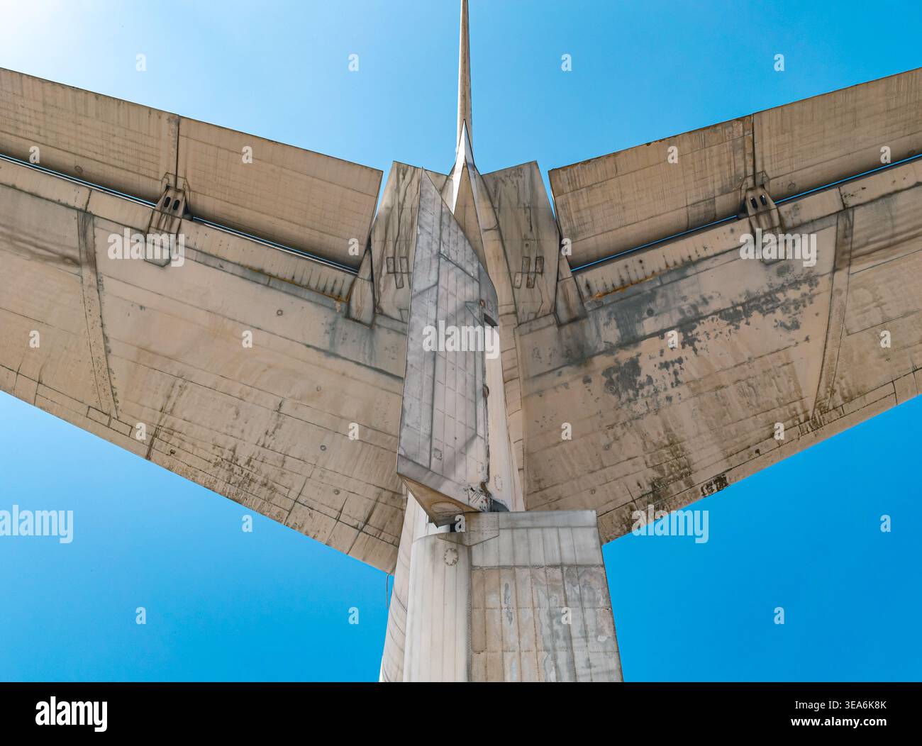 Una vista ravvicinata verso l'alto mostra la parte inferiore sporca e invecchiata degli stabilizzatori di coda orizzontali e verticali di un aereo posti contro un cielo blu. Foto Stock