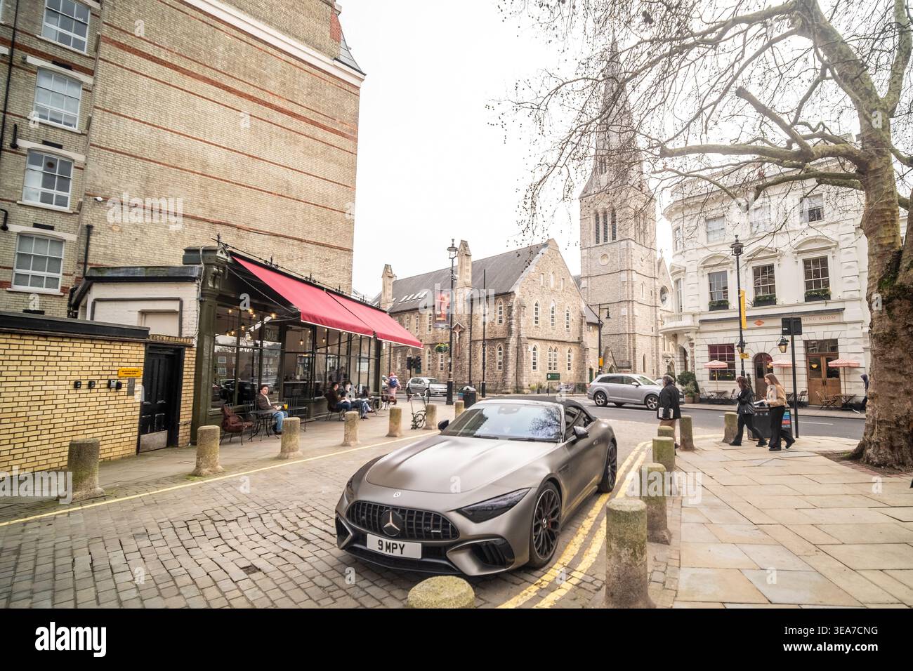 LONDRA - 9 MAGGIO 2026: Orange Square Pimlico Road Belgravia - scena di lusso in Mercedes SL grigia con chiesa storica. Foto Stock