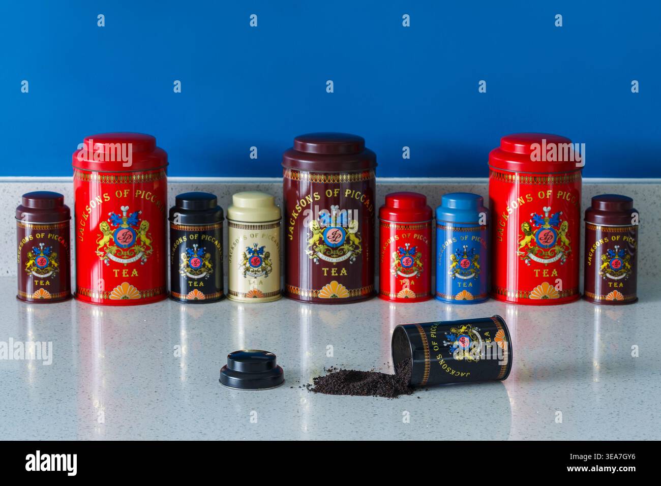 Caddie retrò vintage per tè Piccadilly caddy per tè sul piano di lavoro della cucina con una teglia aperta con il contenuto foglie di tè versate Foto Stock