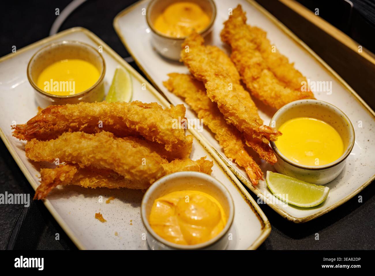 Gamberi tempura croccanti con salse e spicchi di lime Foto Stock