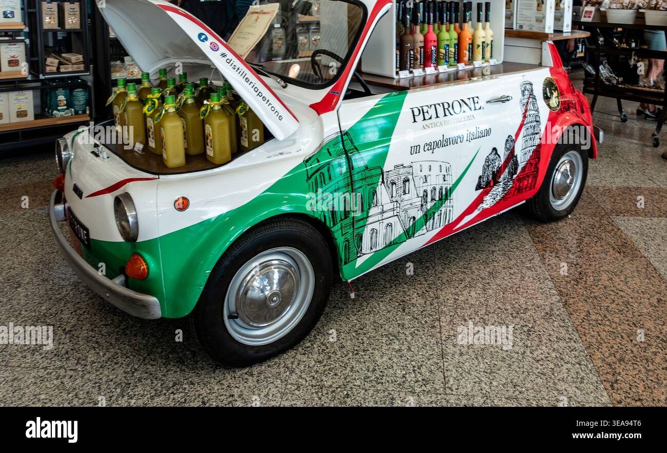 Petrone Antica Distilleria mostra auto presso l'aeroporto di Olbia Costa Smeralda, Italia. La Fiat 500 d'epoca contiene bottiglie di liquore nel suo cappuccio aperto. Foto Stock