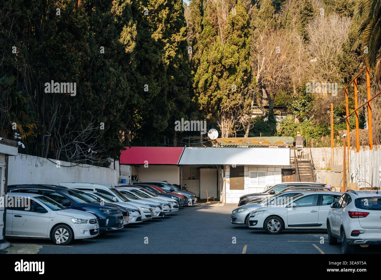 Parcheggio silenzioso. Tranquilla scena suburbana con auto parcheggiate e edificio di servizio Foto Stock