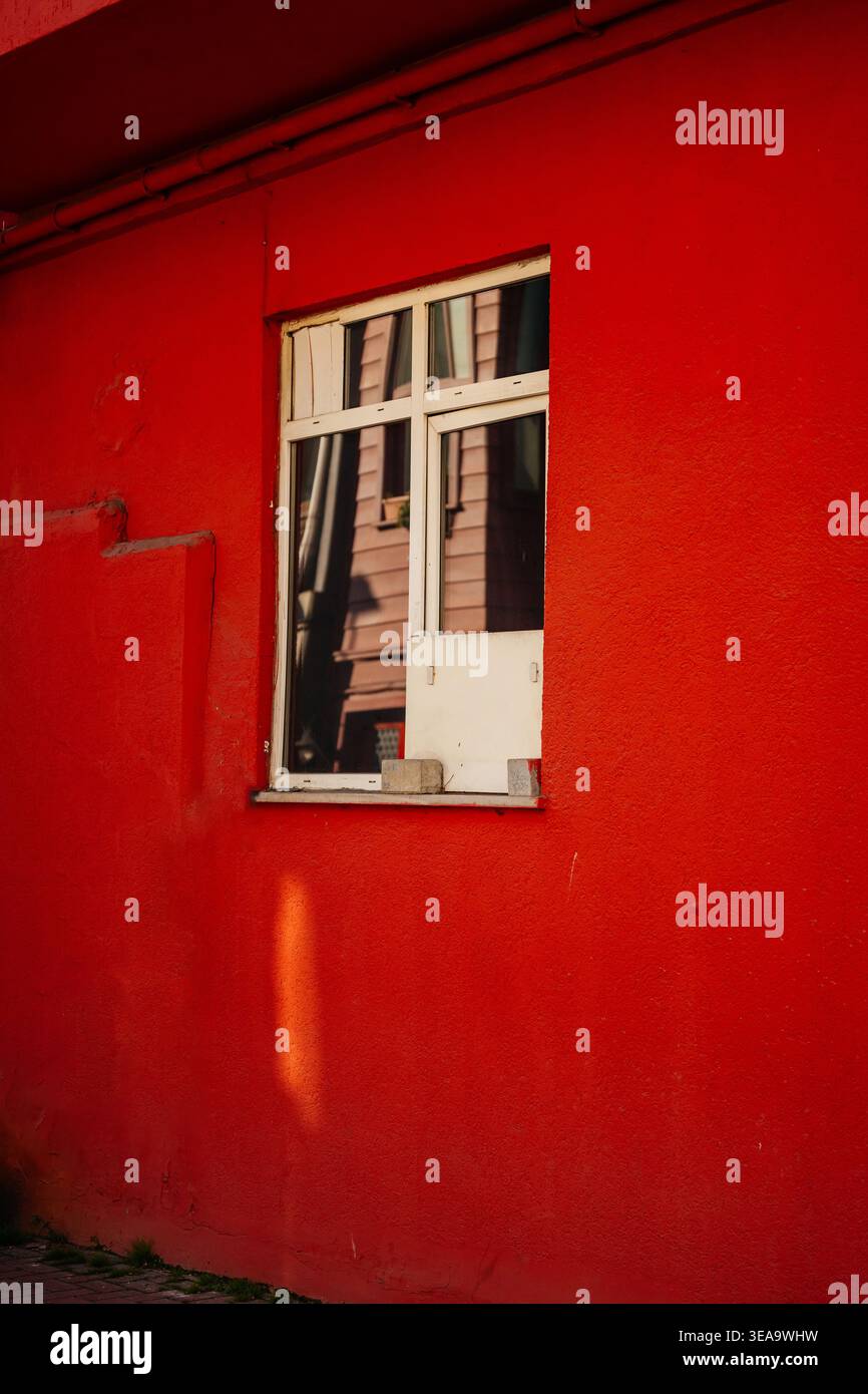 Composizione architettonica contemporanea che mostra riflessioni astratte della città attraverso il vivace Red Pane Foto Stock