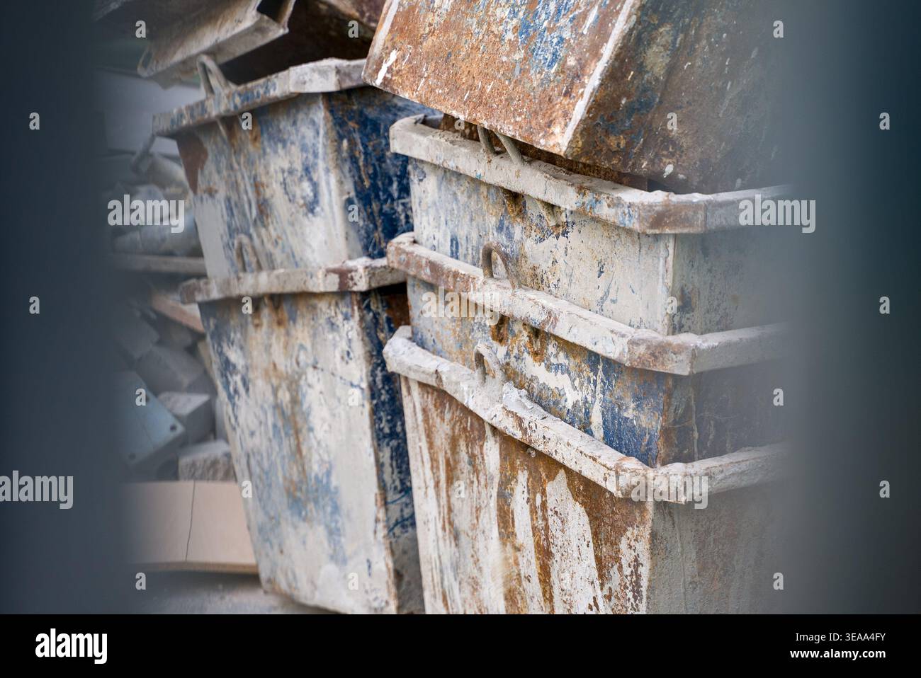 Primo piano di vecchi contenitori in metallo arrugginito in un cantiere che mostrano superfici usurate e texture industriali. Foto Stock