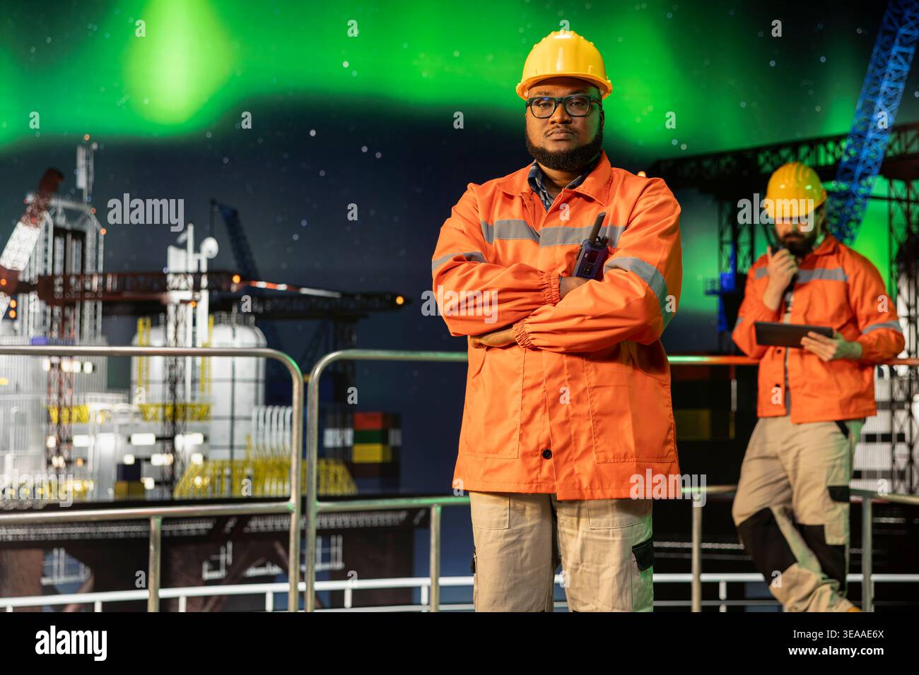 Ritratto del lavoratore della piattaforma marittima offshore che sovrintende alle operazioni durante l'aurora boreale a tarda notte. Chiatta di perforazione marittima professionale che supervisiona le attività di produzione sul ponte sotto le luci artiche Foto Stock