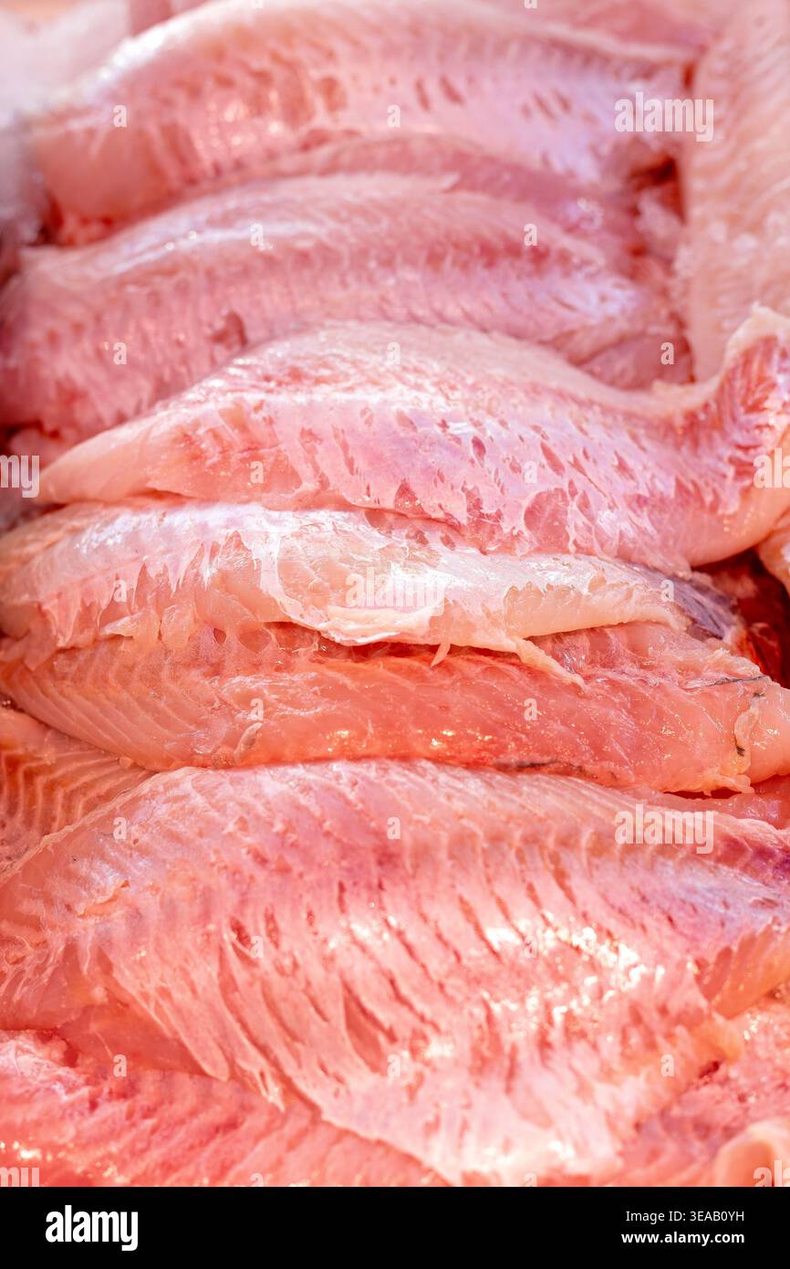 I filetti di pesce vengono visualizzati in un mercato. I filetti sono rosa e freschi, mostrando tagli puliti. La gente potrebbe venire a comprare pesce per cucinare. L'atmosfera lo è Foto Stock