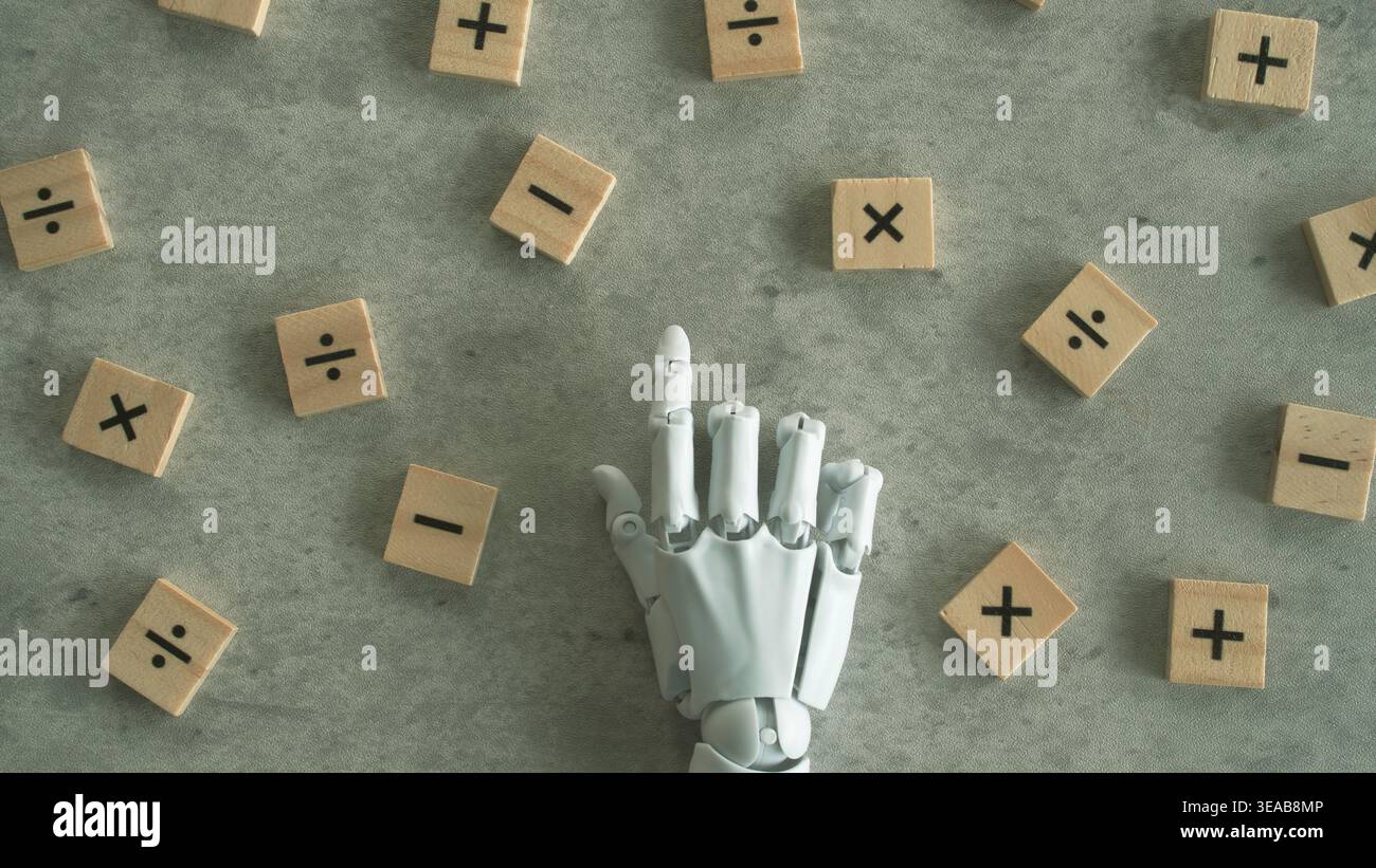 Vista dall'alto verso il basso di una mano di robot bianca centrata tra blocchi di funzionamento matematici sparsi. Foto Stock