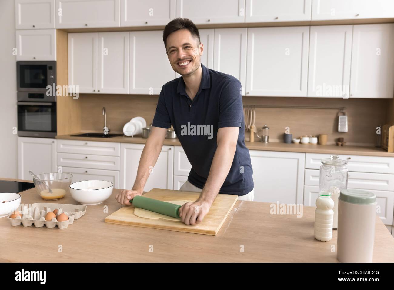 Giovane uomo single che cucina da solo in cucina Foto Stock