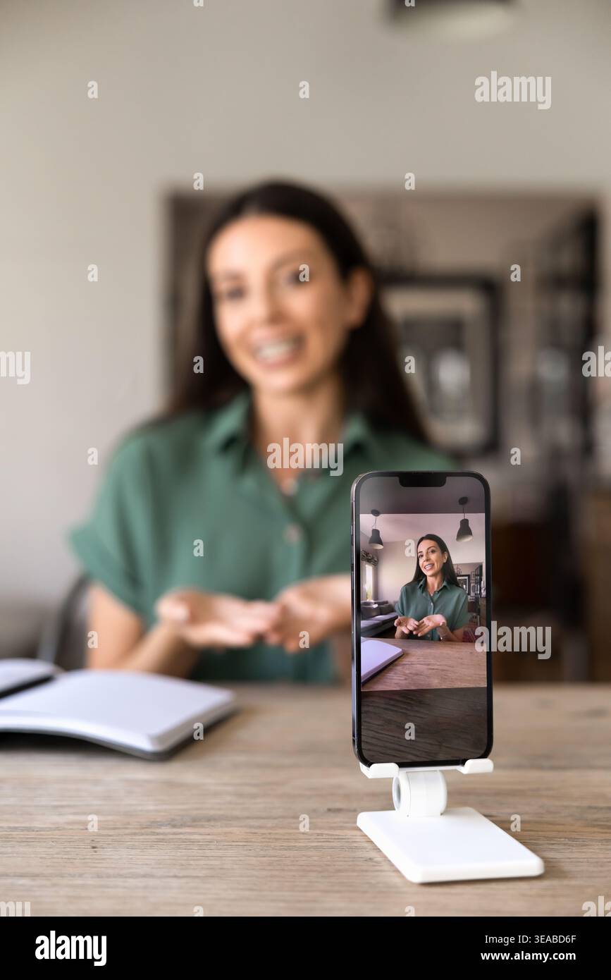 Donna che registra vlog su smartphone a casa Foto Stock