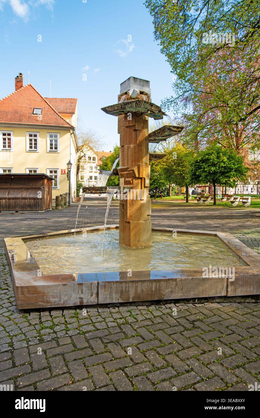 Moderna fontana a Bad Sooden-Allendorf, Assia, Germania, situata in una piazza tranquilla con alberi ed edifici storici. Foto Stock