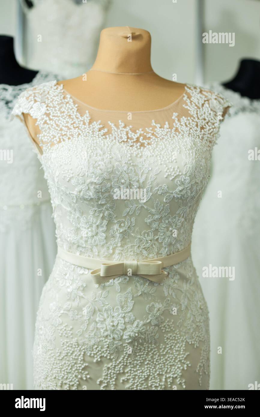 Primo piano di un lussuoso abito da sposa in stile sirena di Pentelei, presentato durante una fiera di nozze del 2017. L'immagine evidenzia l'intricata lac Foto Stock