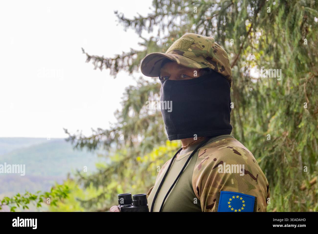 Uno scout in camuffamento analizza le minacce, controlla il territorio e garantisce la sicurezza in condizioni di potenziale conflitto Foto Stock