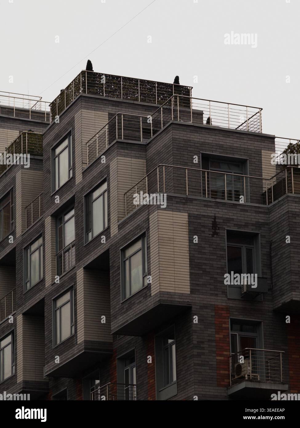 Vista esterna degli edifici residenziali che mostrano forme ripetitive di finestre architettoniche, geometrie e design moderno della facciata. - Immagine stock catturata con smartphone