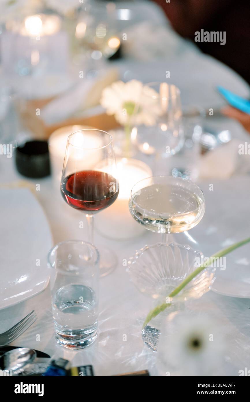 Ambiente elegante con calda luce di candela. Atmosfera serena creata da luci soffuse e raffinati stoviglie Foto Stock