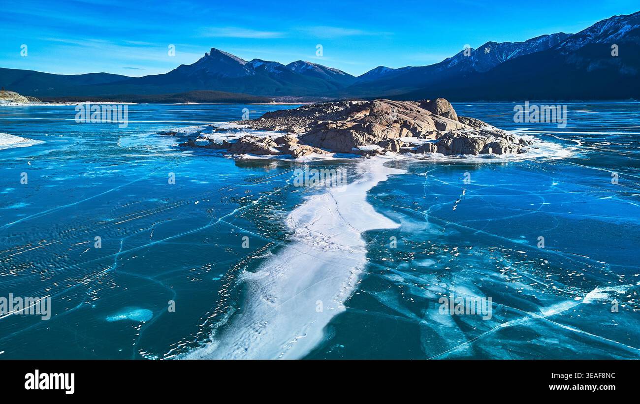 Il lago Abraham, ghiacciato dall'alto, affioramento roccioso e le montagne invernali, Alberta Foto Stock