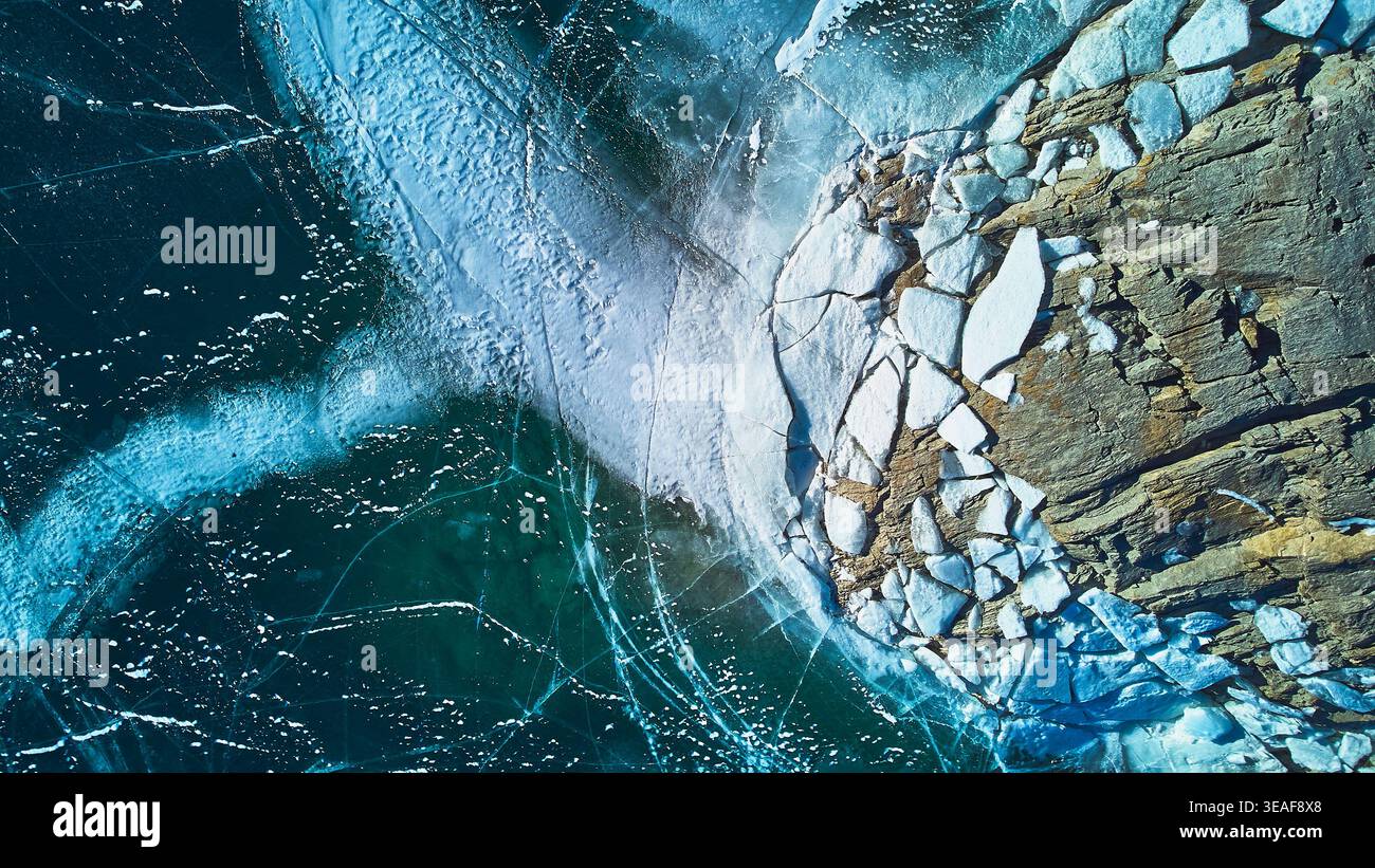 In inverno, il ghiaccio del lago ghiacciato dall'alto e la costa rocciosa Foto Stock