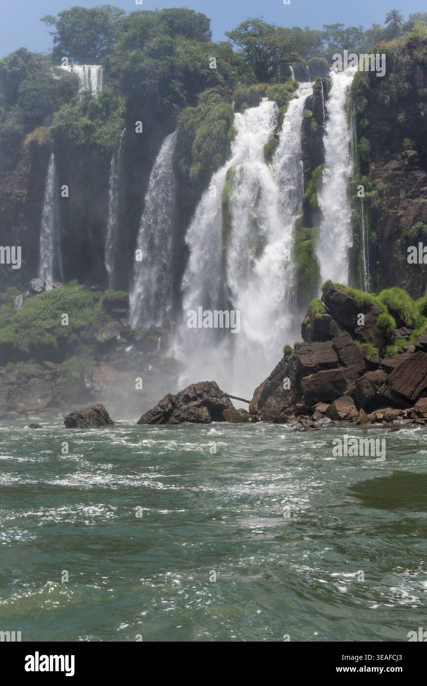 Paesaggio con l'acqua dell'Iguazú inferiore e il salto Mendez nel parco naturale, girato dal basso con la luce brillante dell'estate alle cascate dell'Iguazu, Misiones, Argentina Foto Stock