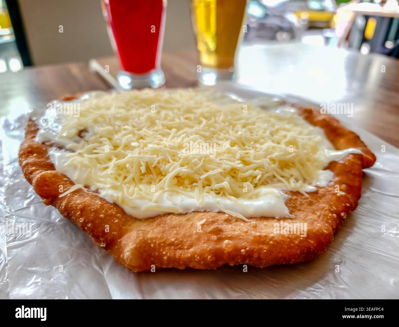 Tradizionale cibo di strada ungherese Langos, impasto fritto con condimenti, popolare spuntino e autentica esperienza culinaria locale in Ungheria Foto Stock