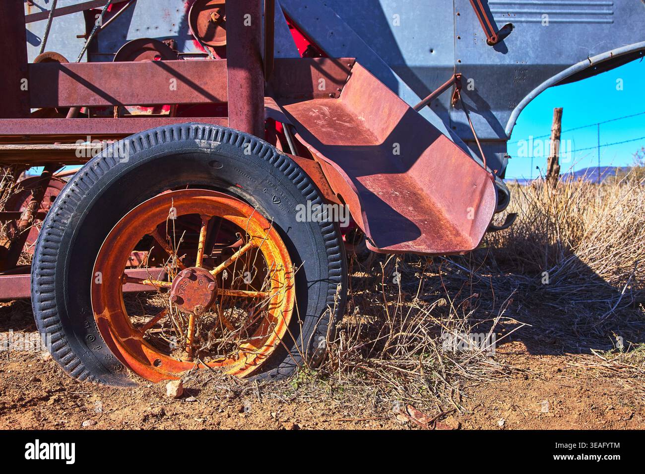Ruota per attrezzature agricole arrugginite d'epoca e dettagli in metallo resistente agli agenti atmosferici in primo piano Foto Stock