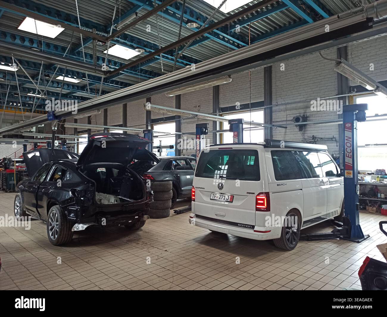 Vilnius, Lituania - 2023-03-21 - Vista interna del posto di lavoro per riparazioni automobilistiche, grande centro di assistenza auto con diverse auto in fase di manutenzione sugli ascensori Foto Stock
