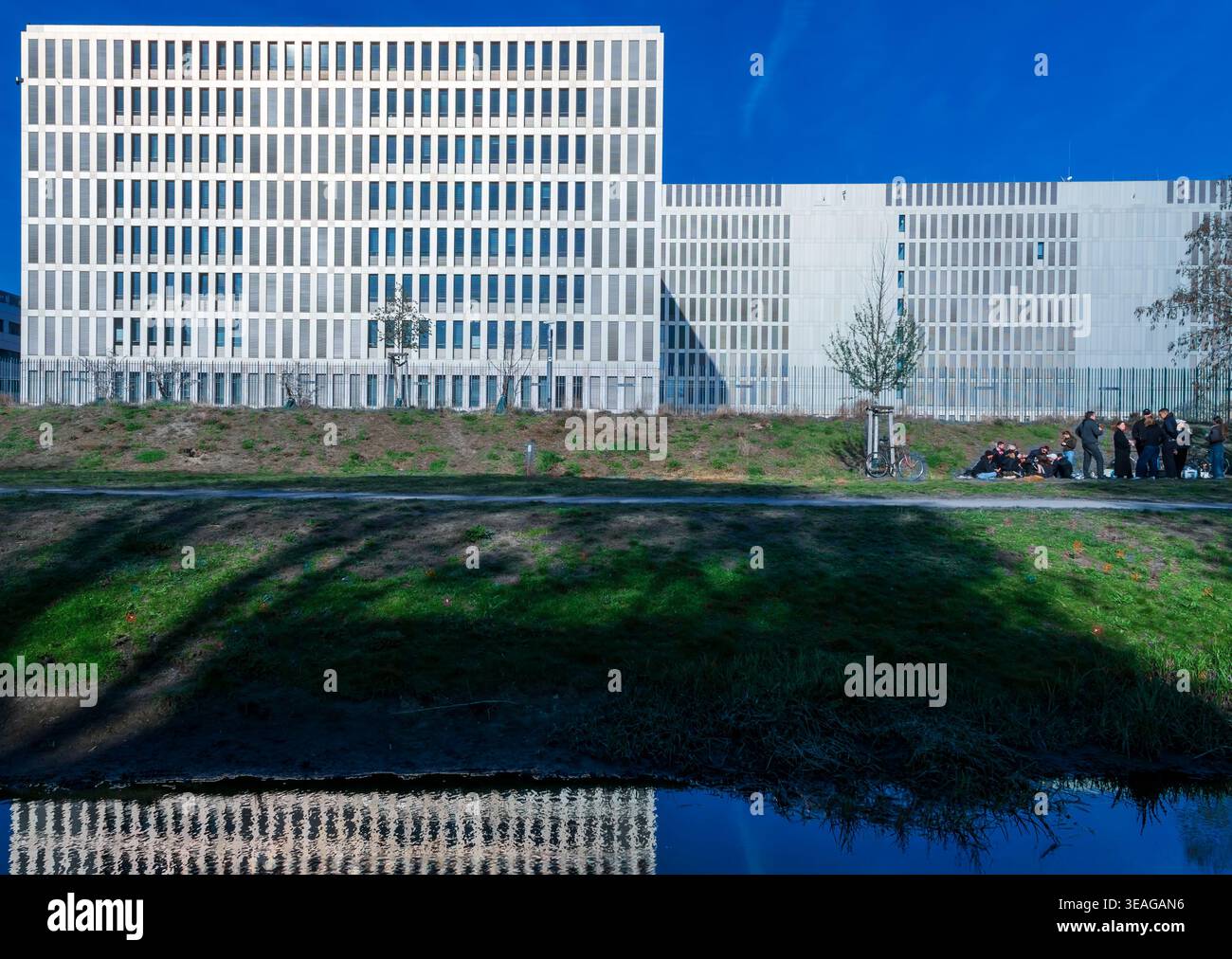 Gruppo di persone sedute vicino ai moderni edifici per uffici del complesso della sede del servizio di intelligence federale (BND) a Berlin Mitte, Germania. Foto Stock