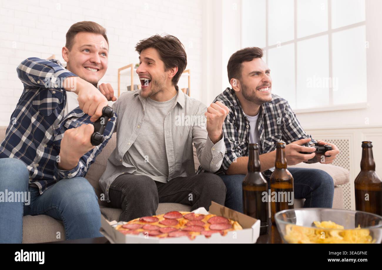 I videogamer accaniti. Uomini eccitati i video-giochi a casa Foto Stock