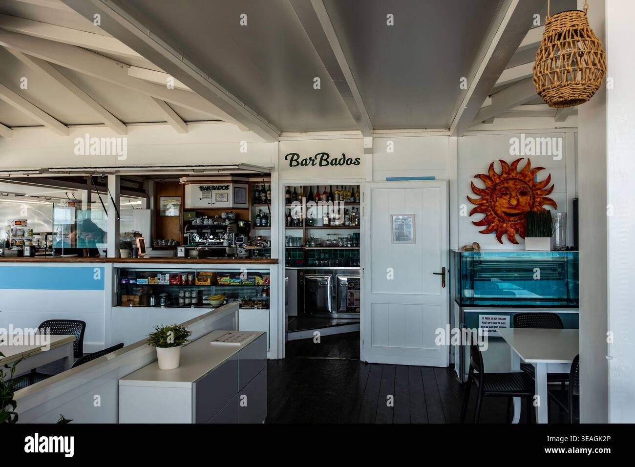 Gli interni delle Barbados, un caffè inados, Olbia, Sardegna, presentano un bancone in legno bianco, scaffali con bottiglie e decorazioni a forma di sole. Foto Stock