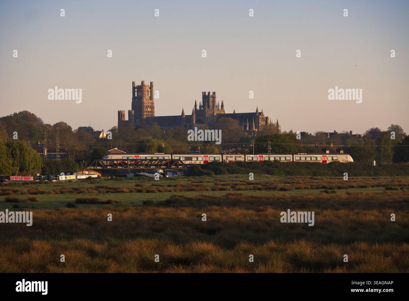 Un treno Stadler 755 FLIRT che passa per la cattedrale di Ely, Cambridgeshire, Regno Unito Foto Stock
