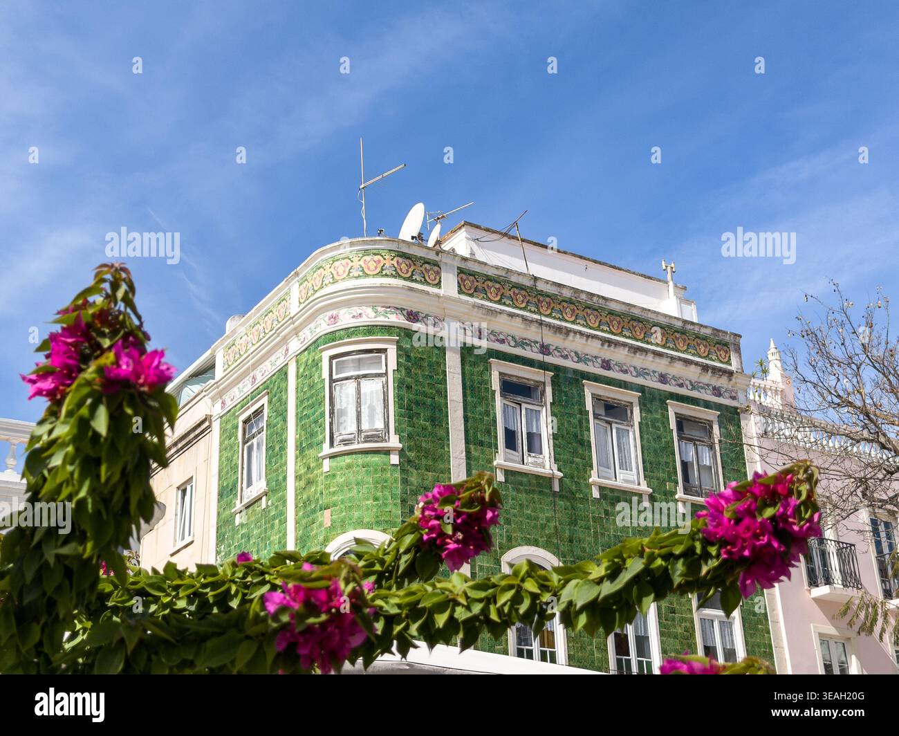 Edificio storico con piastrelle verdi di azulejo incorniciate da fiori di bouganville rosa cielo azzurro in piazza Luis de Camoes, casa verde di lagos Portogallo Foto Stock